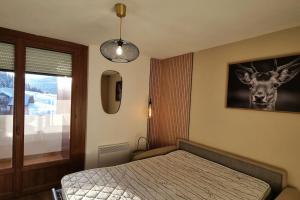 1 dormitorio con 1 cama con una foto de un ciervo en la pared en Le Montagnard, en Mijoux
