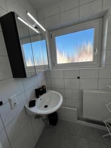 baño blanco con lavabo y ventana en Feel like Home 2, en Biberach an der Riß