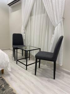 two chairs and a table in a bedroom at منتجع شمس in Buraydah