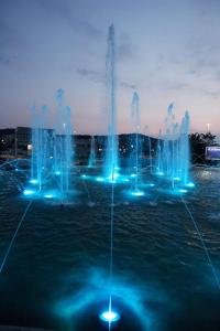 einen Brunnen mit blauen Lichtern im Wasser in der Nacht in der Unterkunft Morski užitek “sea delight” in Koper