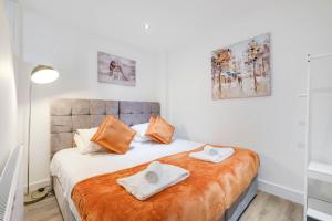 a bedroom with a bed with two towels on it at Reading Town Centre 1 & 2 Bedroom Apartments with Parking by 360Stays in Reading