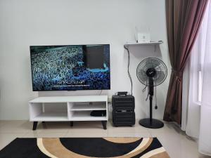 a living room with a tv and a fan at AINOR@Stay Homestay Sendayan in Labu