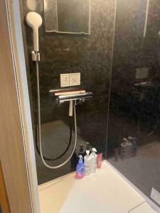a shower in a bathroom with a glass shower backdoor at House surrounded by beautiful nature. in Biei