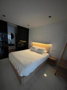 Un dormitorio con una gran cama blanca en una habitación. en Suite PLAYAMAR con jacuzzi, en Torremolinos