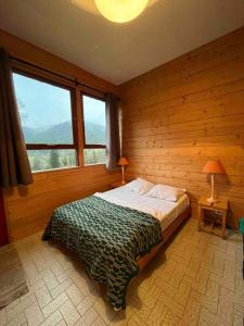 a bedroom with a bed in a wooden wall at Serene Wilderness Getaway for 15 next to a historic castle 
