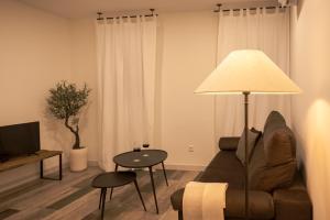 a living room with a couch and a table with a lamp at La casona de Torremocha de Jarama in Torremocha de Jarama