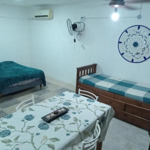 a room with two beds and a table with a remote control on it at Acogedor y familiar departamento c est in Santiago del Estero