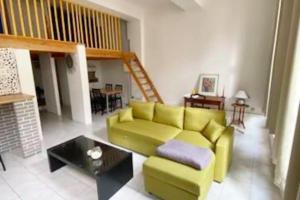 uma sala de estar com um sofá verde e uma mesa em Appartement Idéal en centre ville em Montpellier