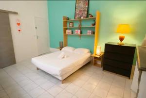 ein Schlafzimmer mit einem weißen Bett und einer blauen Wand in der Unterkunft Appartement Idéal en centre ville in Montpellier