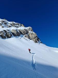 eine Person, die einen schneebedeckten Berg hinuntergeht in der Unterkunft Chalet montagne Savoie Domaine Skiable Valmorel in La Lechere