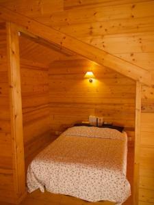 1 dormitorio con 1 cama en una cabaña de madera en Chalet montagne Savoie Domaine Skiable Valmorel, en La Lechere