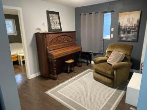 a living room with a chair and a piano at Suite Sunrise in Vancouver