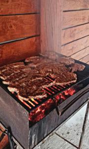 a grill with a bunch of meat on it at Cabana Alexe Mărișel in Mărişel
