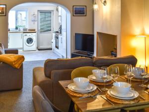 a living room with a couch and a table with wine glasses at Hugh Cottage in Whitehaven