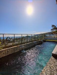 a swimming pool with the beach in the background at La tête dans les airs, les pieds dans l’eau! in Saint-Denis