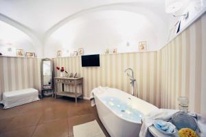 La salle de bains est pourvue d'une baignoire et d'une télévision murale. dans l'établissement SECRET GARDEN apartment, à Castellammare di Stabia