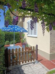 a fence with an umbrella in front of a house at Casa Rosa Marina di Cecina in Cecina