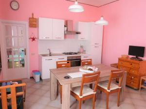 a kitchen with a wooden table and chairs in a room at Casa Rosa Marina di Cecina in Cecina
