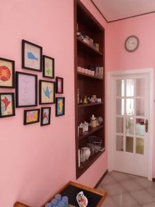 a room with a pink wall with pictures on it at Casa Rosa Marina di Cecina in Cecina