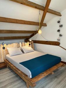 1 dormitorio con cama de madera y manta azul en Villa K'nell - La Possession, en La Possession