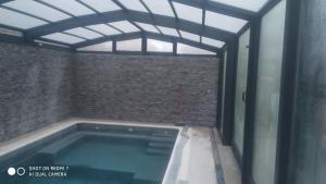 a swimming pool in a room with a brick wall at Casa Rural Aguachales in Villanueva-Matamala