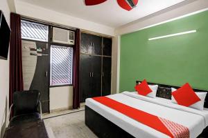 une chambre avec un lit avec des oreillers rouges et une fenêtre dans l'établissement Hotel O D 3 residency, à Ghaziabad