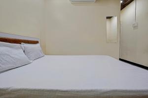 1 cama blanca grande en una habitación blanca en OYO Sai Villa Lodging & Bording, en Bombay