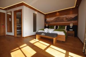 ein Schlafzimmer mit einem Bett und einer Bank in einem Zimmer in der Unterkunft Hotel-Garni "Das Seebichl" in Achenkirch