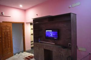 un soggiorno con TV a parete di Harisri Homestay a Madurai