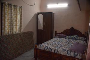 um quarto com uma cama, uma cómoda e um espelho em Harisri Homestay em Madurai