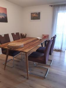 a dining room table with chairs and a wooden table at Ferienwohnung am Stehlesee in Herrischried