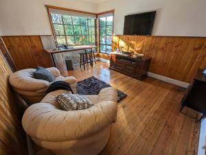 a living room with two couches and a television at Lyell Cottage Queenstown Comfortable and Warm in Queenstown
