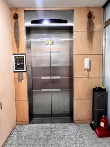 une porte d'ascenseur dans un immeuble avec téléphone dans l'établissement Ho Home Tel, à Séoul