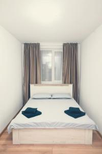una camera da letto con un letto bianco con due cuscini sopra di Robert's Apartment a Bistriţa