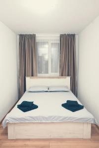 un letto bianco con due cuscini blu sopra di Robert's Apartment a Bistriţa