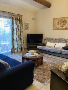 a living room with a couch and a table at La Petite Garrigue in Mérindol