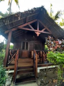a house with a wooden staircase leading to a porch at Le Moya Beach in Nosy Be