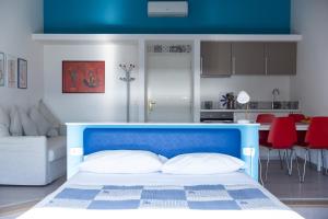 a bedroom with a blue and white bed and a kitchen at Palazzo Mirelli in Naples