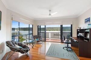 a living room with a desk and chairs and a table at Waterfront, Deep Water Pontoon, views to Straddie in Russell Island