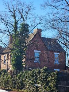 a red brick house with a tree in front of it at Hollies House in Retford
