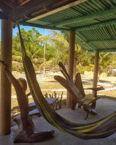 una hamaca en un porche con vistas a la playa en Chalé Ilha Verde-Cumuruxatiba, en Cumuruxatiba