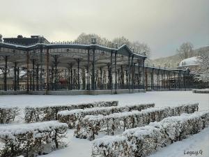 um jardim coberto de neve com um gazebo em Le Petit Logis em Jalhay