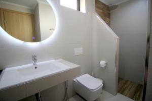a bathroom with a sink and a toilet and a mirror at Ortus Rooms in Sarandë