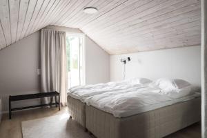 a large bed in a room with a large window at Cottage Charm - Cozy Getaway in the Archipelago in Naantali