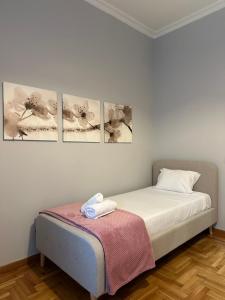 un letto in una stanza con quattro immagini sul muro di Sm Athens ad Atene