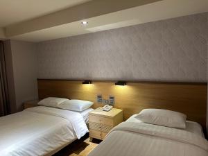 Rúm í herbergi á Rich & Free Hotel - Fuzhong 富逸旅趣-板橋府中館