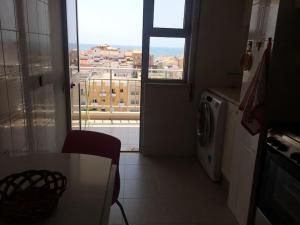 a kitchen with a view of a city from a window at Perfect for two in Armação de Pêra
