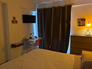 a bedroom with a bed and a desk and a television at Perfect for two in Armação de Pêra