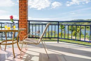 a balcony with a table and chairs and a view of the water at KARIBA SUN BEACH APARTMENT in Rutsiro