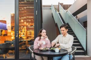 a man and woman sitting at a table eating food at HOTEL HILLARYS Akasaka in Tokyo